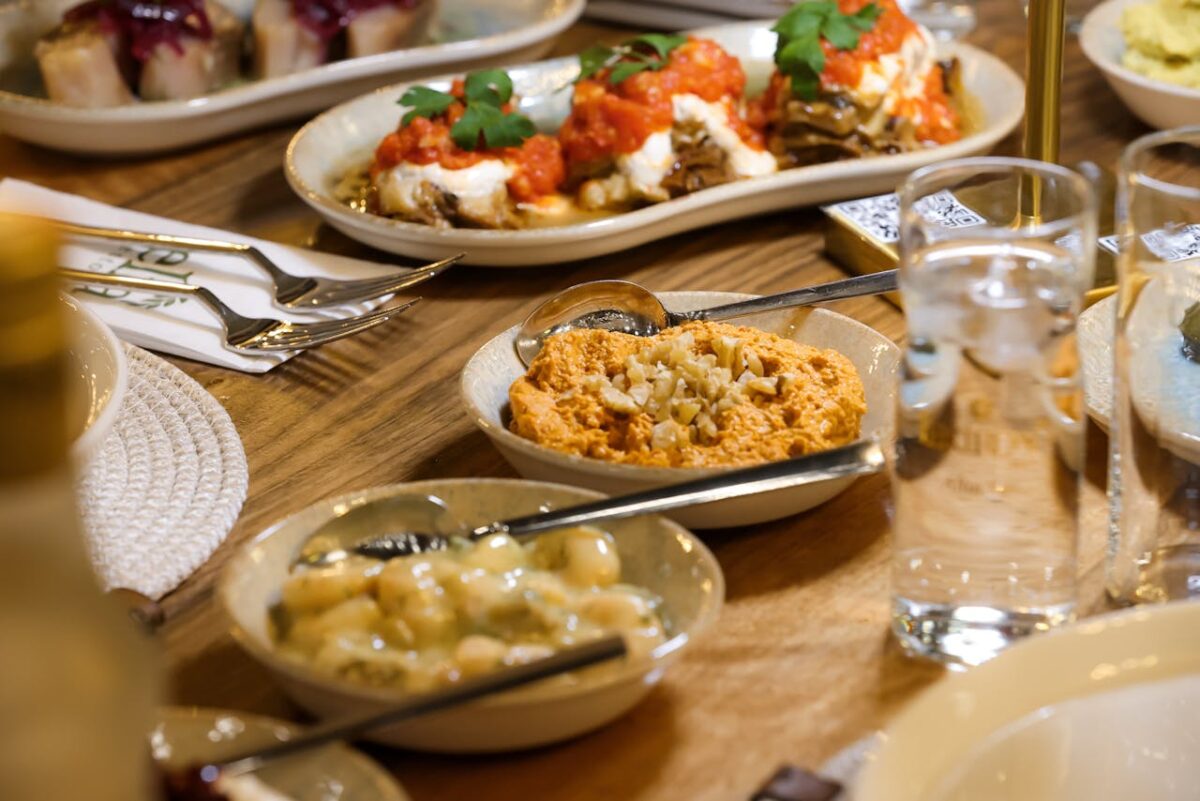 A variety of Mediterranean dishes arranged on a wooden table for a shared dining experience.
