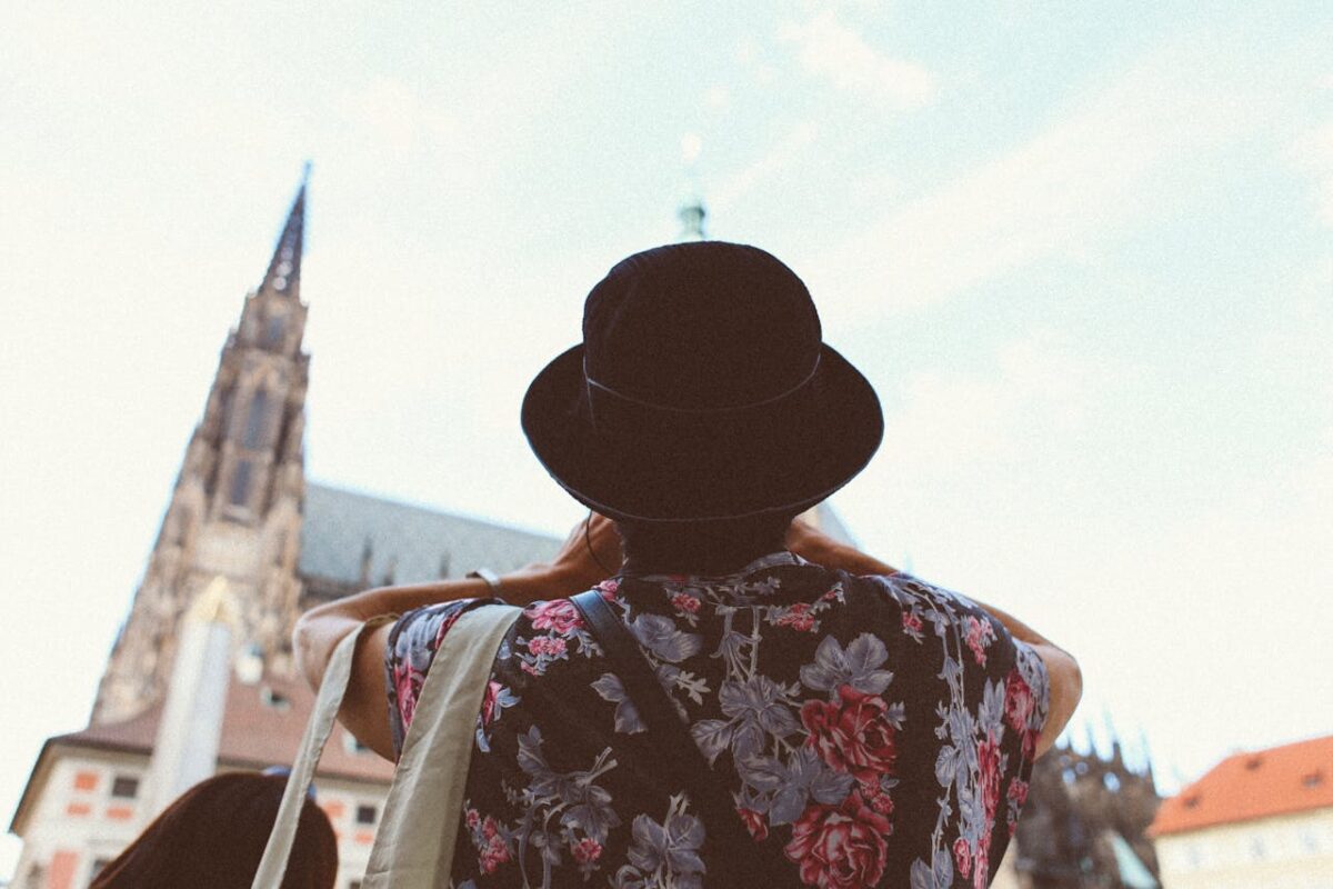Traveler wearing floral shirt and hat captures historic church. Perfect for travel concepts.